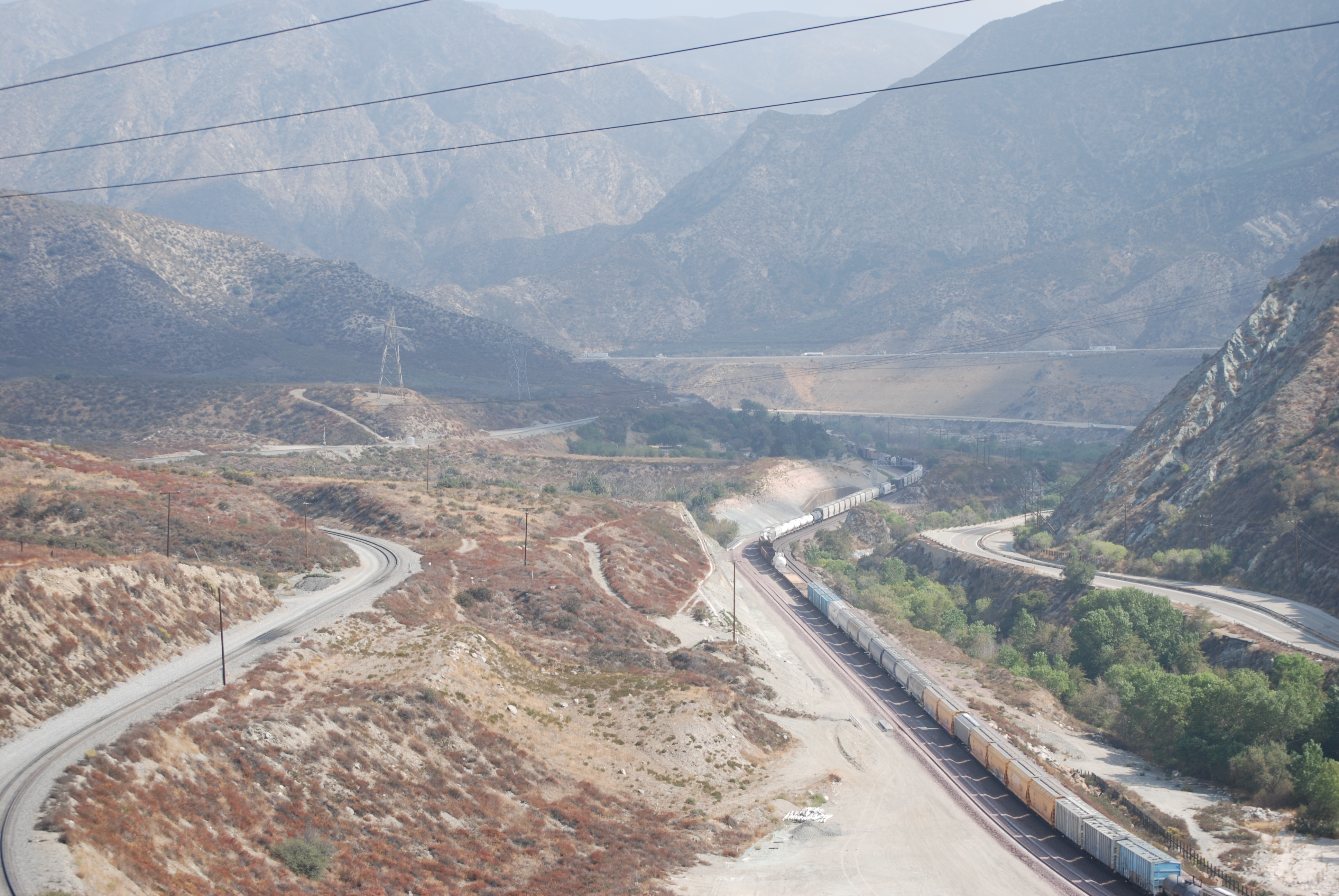 Cajon Pass, CA, where high pressure gas lines, high voltage power lines, rail lines, fiber optics, water lines, and Interstate 15 all run over the San Andreas Fault, which runs roughly side to side across the center of this image. Cajon Pass, CA, where high pressure gas lines, high voltage power lines, rail lines, fiber optics, water lines, and Interstate 15 all run over the San Andreas Fault, which runs roughly side to side across the center of this image.